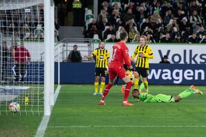 Wolfsburgs Lukas Nmecha (r) erzielt gegen Dortmunds Torwart Gregor Kobel die Entscheidung zum 2:0., © Swen Pförtner/dpa