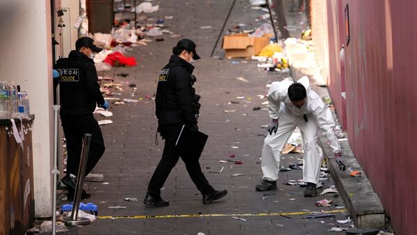 Polizisten ermitteln am Unglücksort der Massenpanik., © Lee Jin-Man/AP/dpa