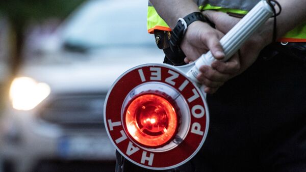 Ein Polizist hält bei einer Verkehrskontrolle eine Winkerkelle in der Hand., © Paul Zinken/dpa/ZB/Symbolbild