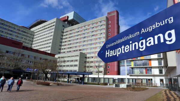 Ein Schild weist zum Haupteingang des neuen Universitätsklinikums Augsburg., © Karl-Josef Hildenbrand/dpa/Archivbild