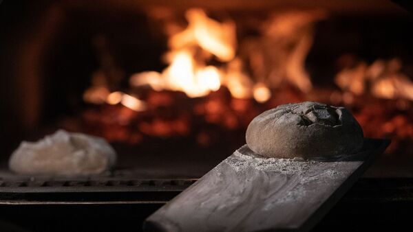 Zwei Brotteige liegen in einem Feuerofen einer Bäckerei., © Swen Pförtner/dpa/Symbolbild