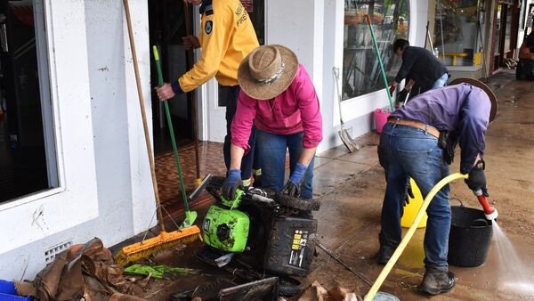 Freiwillige Helfer und Geschäftsinhaber beseitigen nach den Überschwemmungen in der Stadt Molong in der Region Central West von New South Wales Trümmer und Schlick aus den Gebäuden., © Murray Mccloskey/AAP/dpa