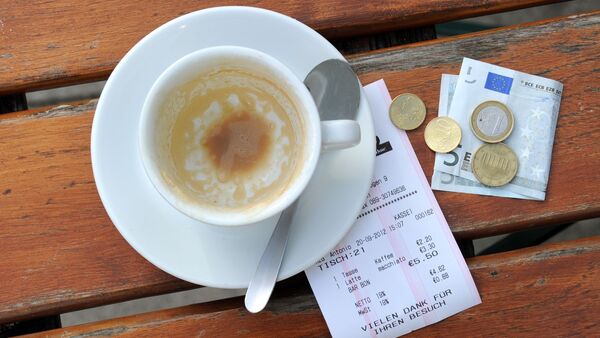 Münzen, ein Geldschein und eine Rechnung liegen neben einer leeren Kaffeetasse auf einem Tisch in einem Restaurant., © Tobias Hase/dpa