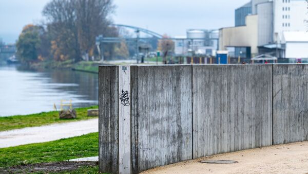 Eine Mauer zum Schutz vor Hochwasser steht am Westhafen., © Armin Weigel/dpa