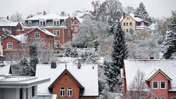 Die Dächer der Häuser in einem Wohngebiet sind mit Schnee bedeckt., © Daniel Vogl/dpa