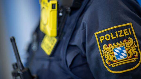 Eine Polizistin trägt ein Abzeichen der bayerischen Polizei., © Daniel Karmann/dpa/Symbolbild